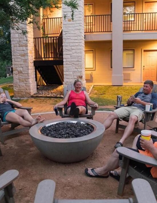 4 friends sitting by outdoor fire pit